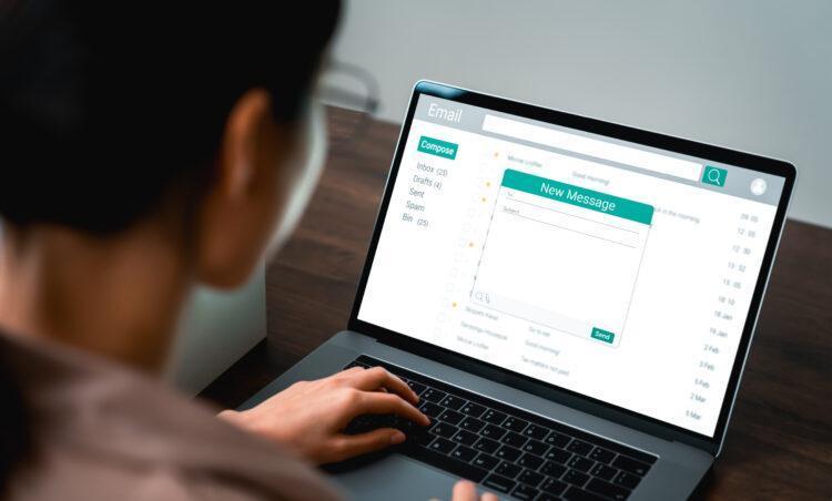 Woman using computer on table with new email message on laptop