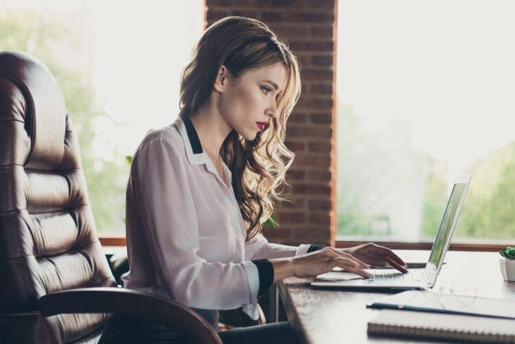 Young female executive typing on her laptop at the office