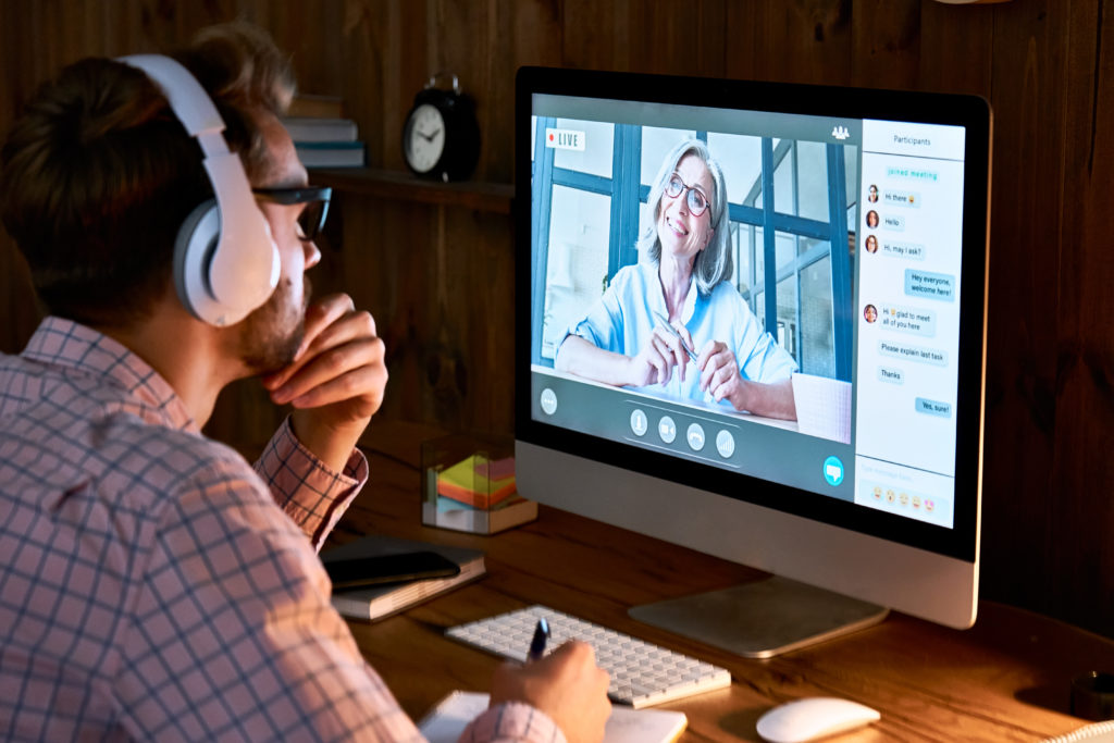 Male student wearing headphones while taking online course.