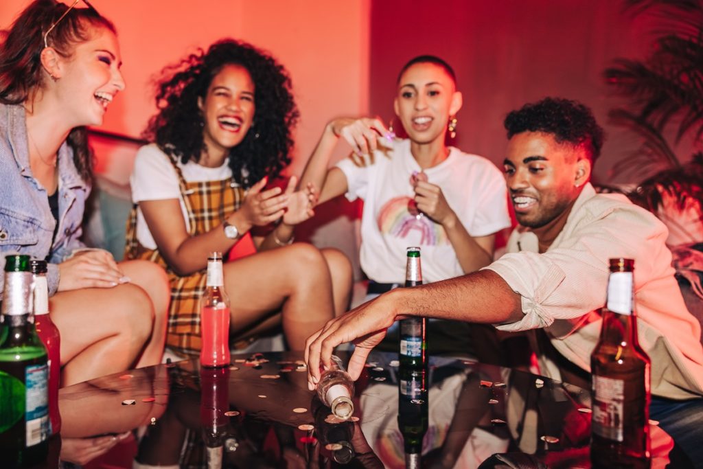 Young group of friends drinking, having fun at a house party.