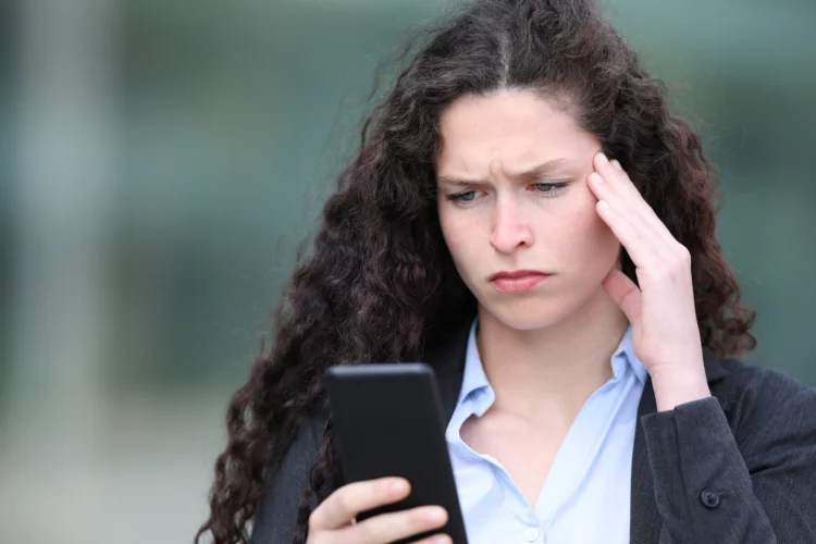 serious woman checking smartphone while outdoors