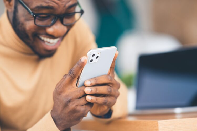 Man smiling at phone after learning the meaning of gng on tiktok.