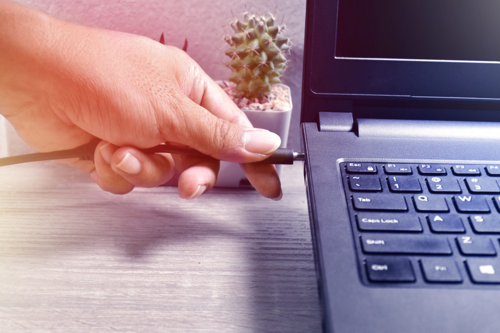 Plugging the USB cord into a laptop.