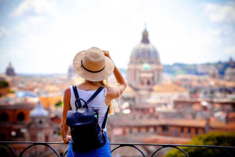 young tourist wearing a sun hat with backpack and a camera