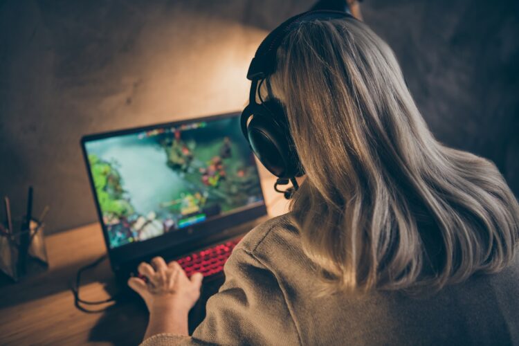 skilled professional focused concentrated gray-haired blonde grandma playing VR game spending holiday at industrial loft modern concrete style interior