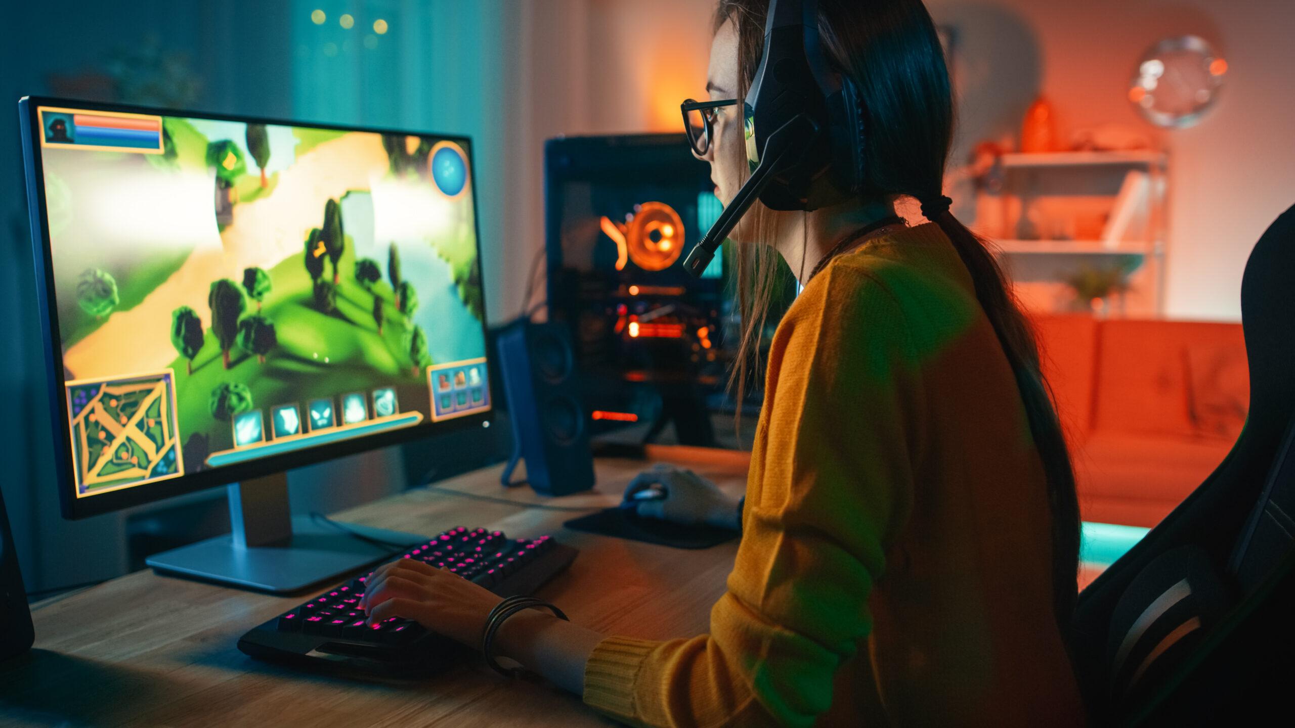 Excited and Concentrated Gamer Girl in Glasses and Headset with
