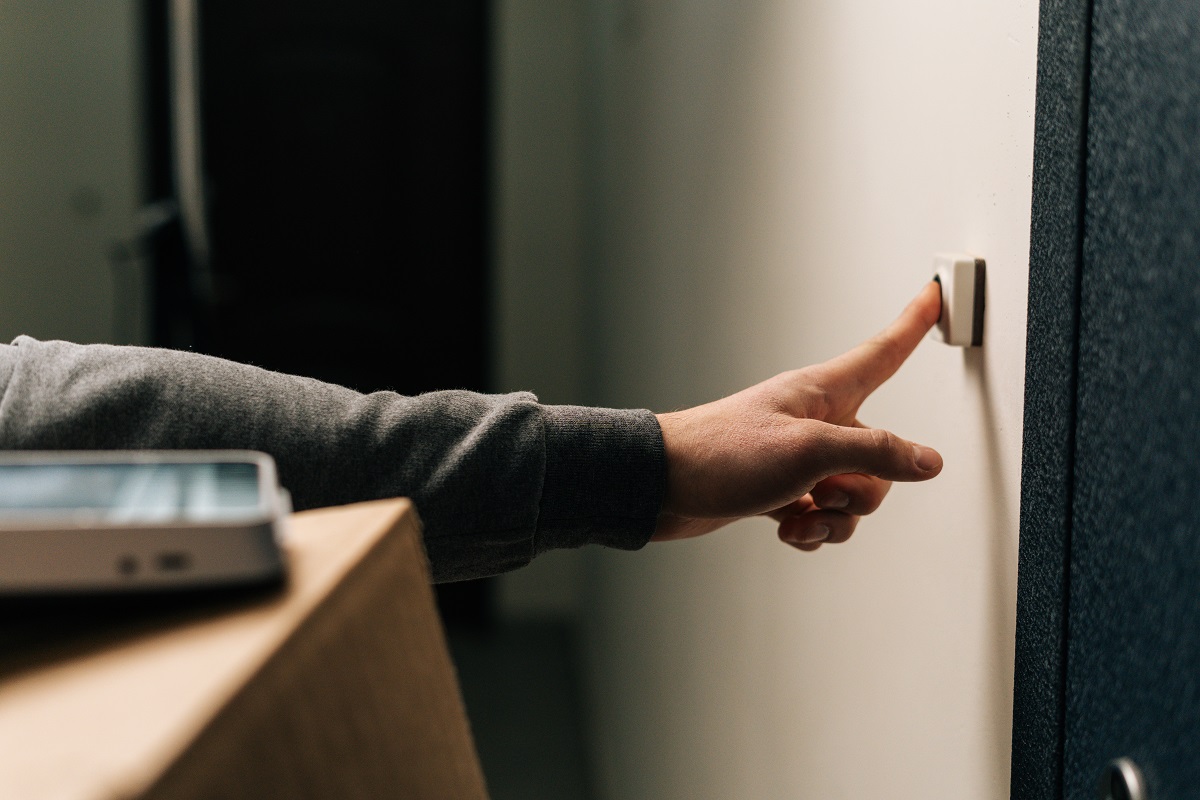 Delivery man ringing doorbell of customer apartment holding a package