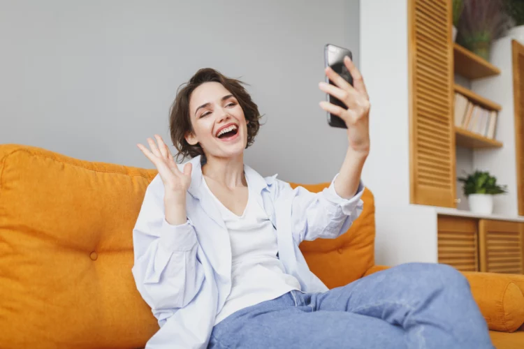 happy girl in living room talking to someone on a video call