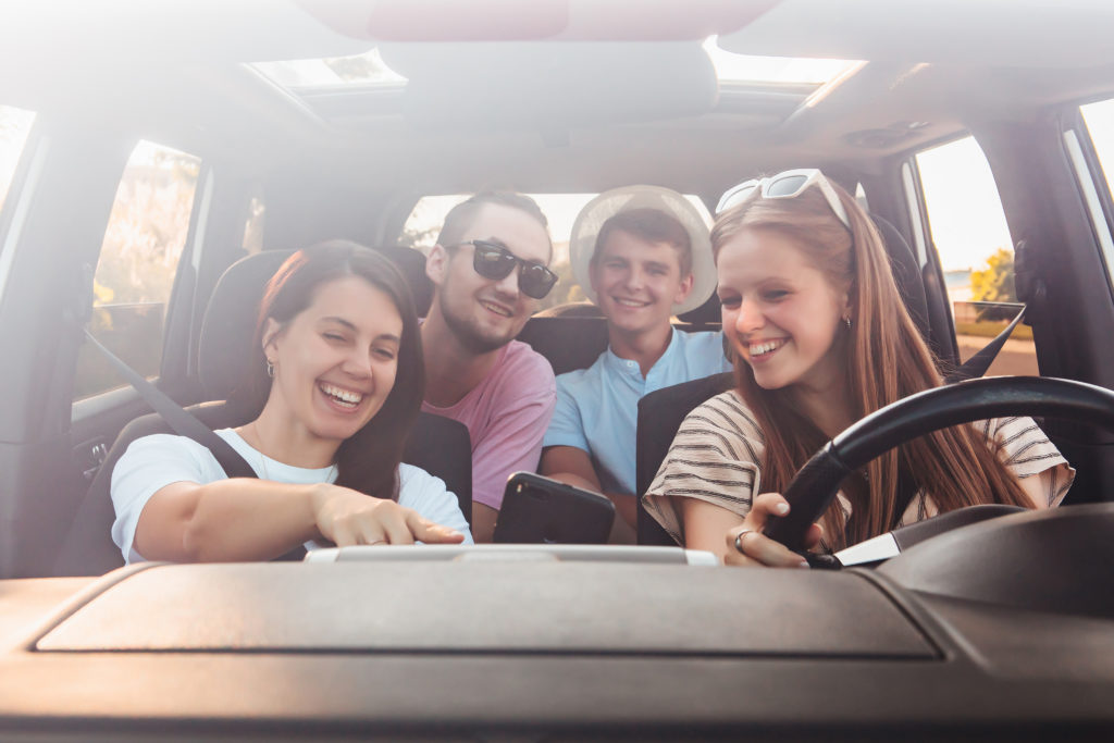 Friend inside a car and looking at one phone.