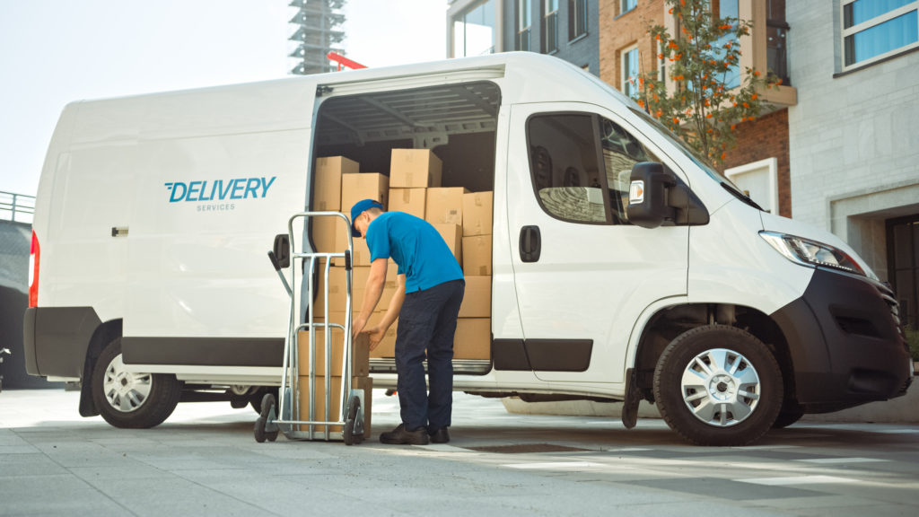Open courier van with boxes out for delivery.