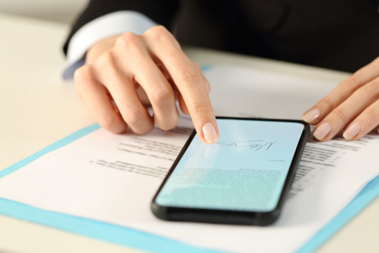 Woman hands signs contract on smart phone