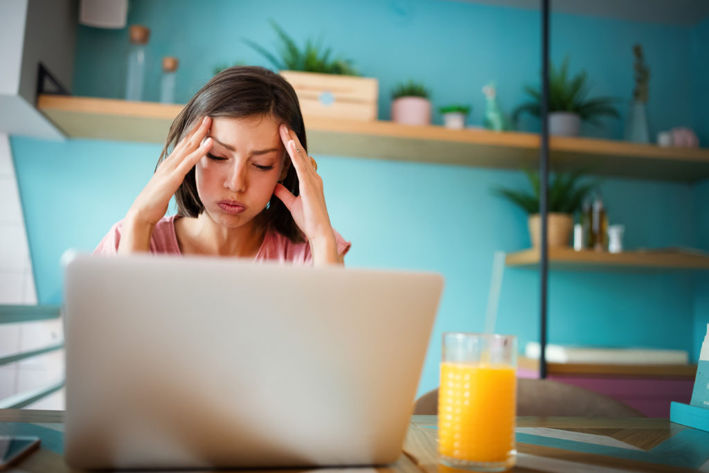 Displeased woman sitting in front of the laptop.