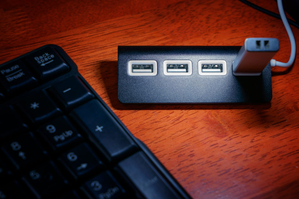 Black USB hub with memory card on the table near keyboard
