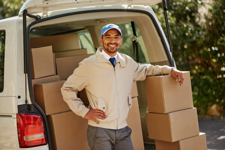 a friendly delivery man unloading cardboard boxes from his van.