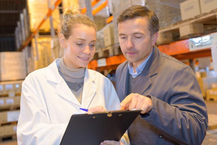 male and female warehouse workers looking at paperwork