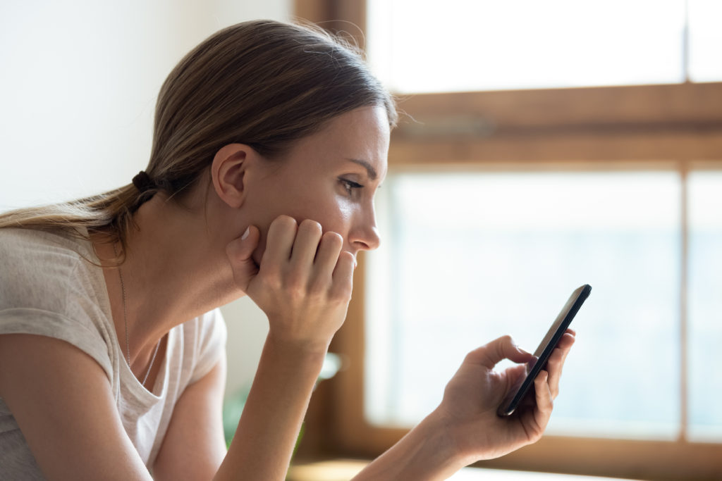 Pensive woman waiting for text message.