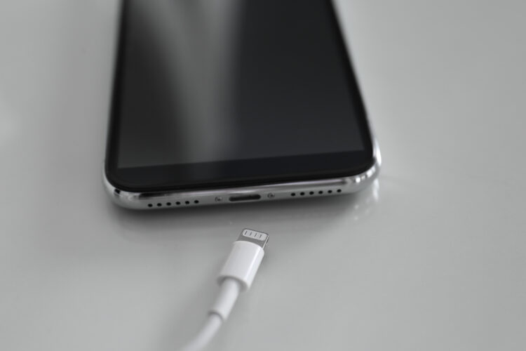 Mobile phone and charging cable on white table
