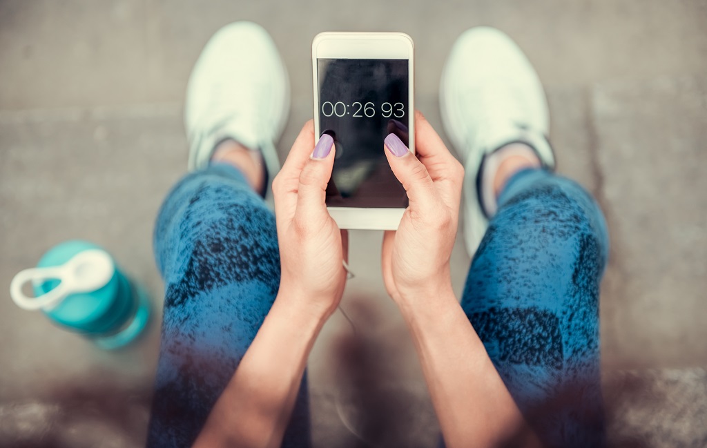 Woman setting a timer on her smartphone.