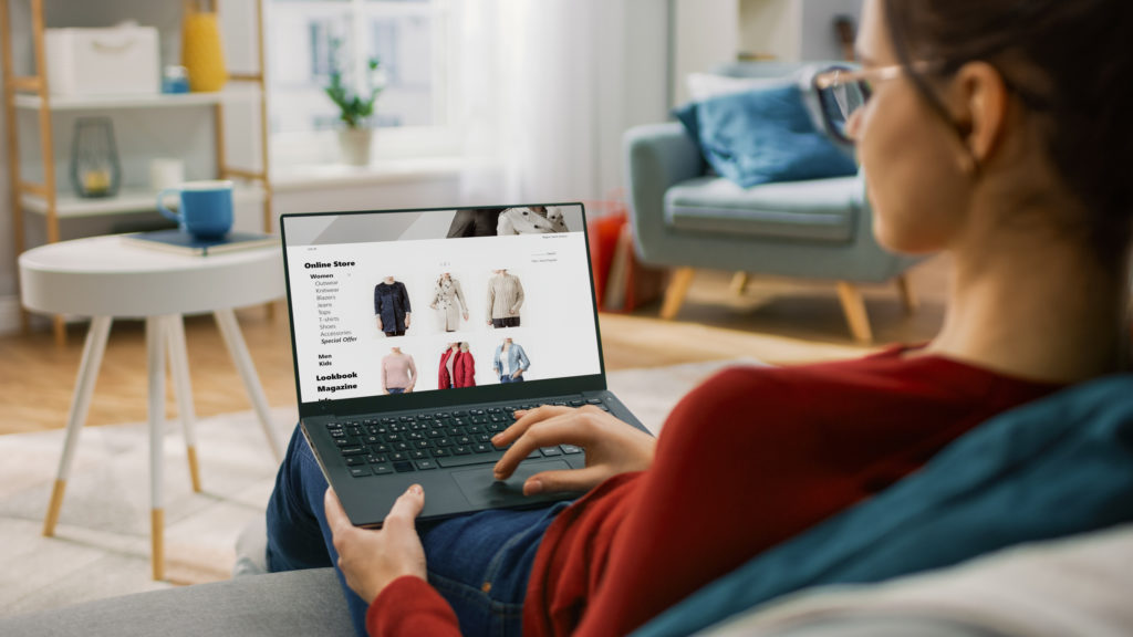 Young woman at home using laptop computer for browsing an online store 