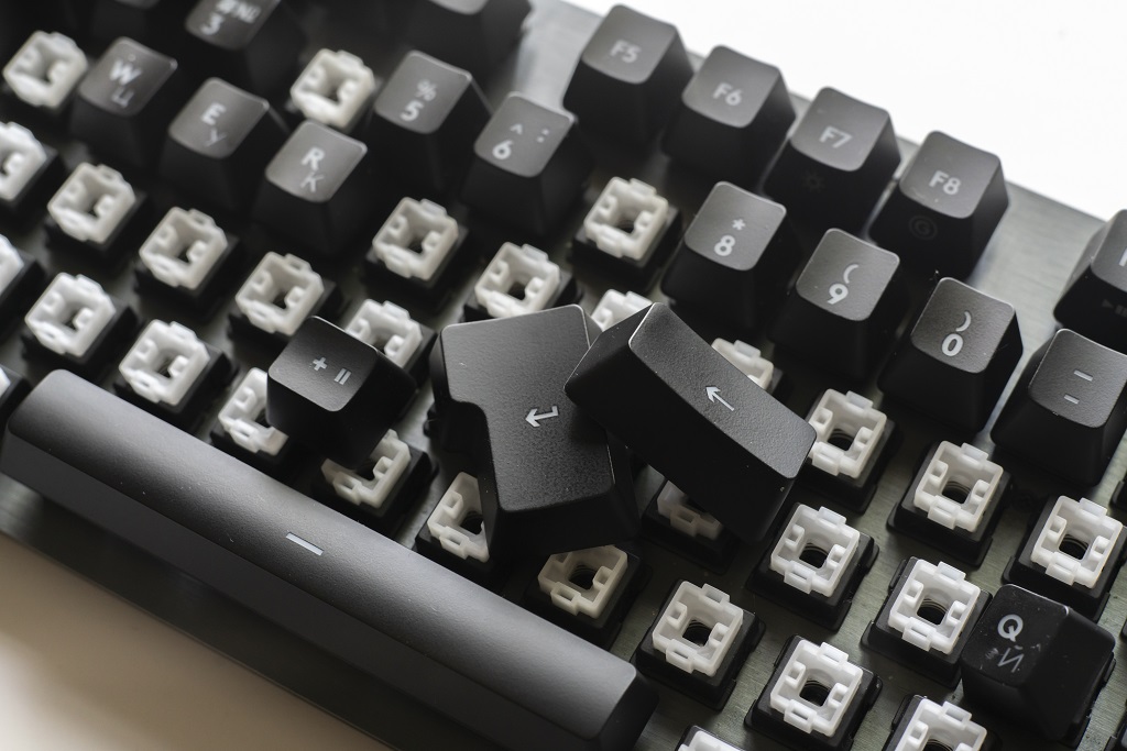 A modern mechanical keyboard switches, black and white keycaps on the desk.