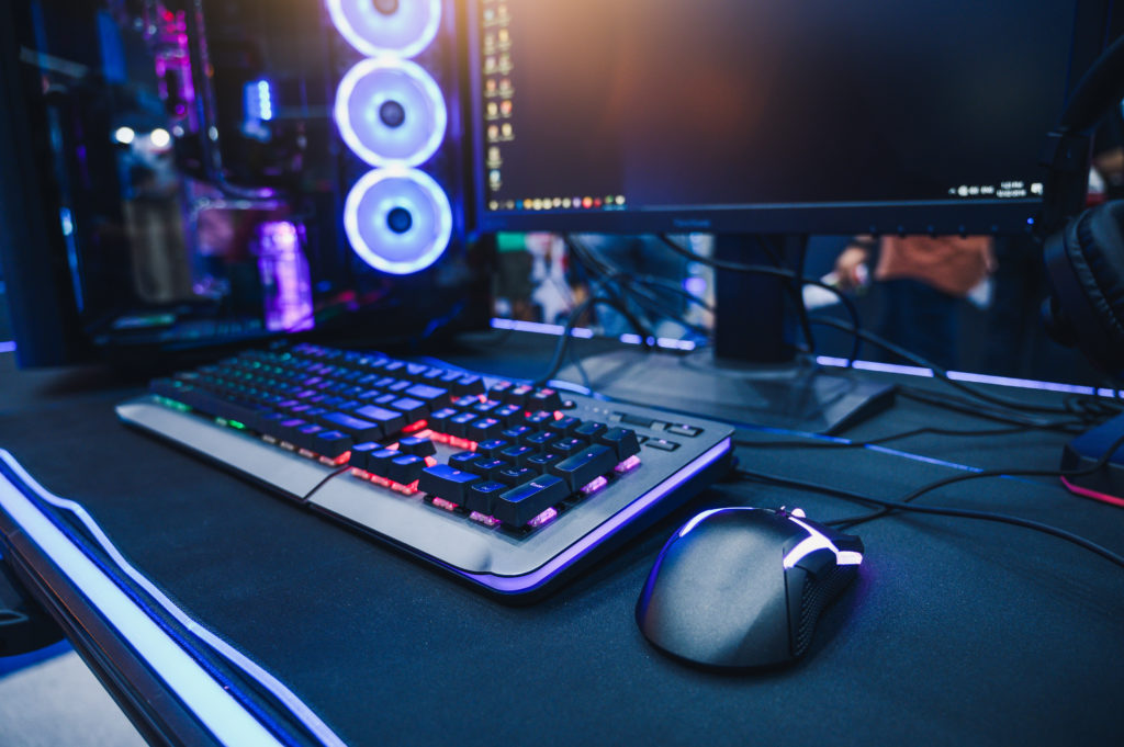 A gamer's desk consisting of the desktop computer and gaming gear.