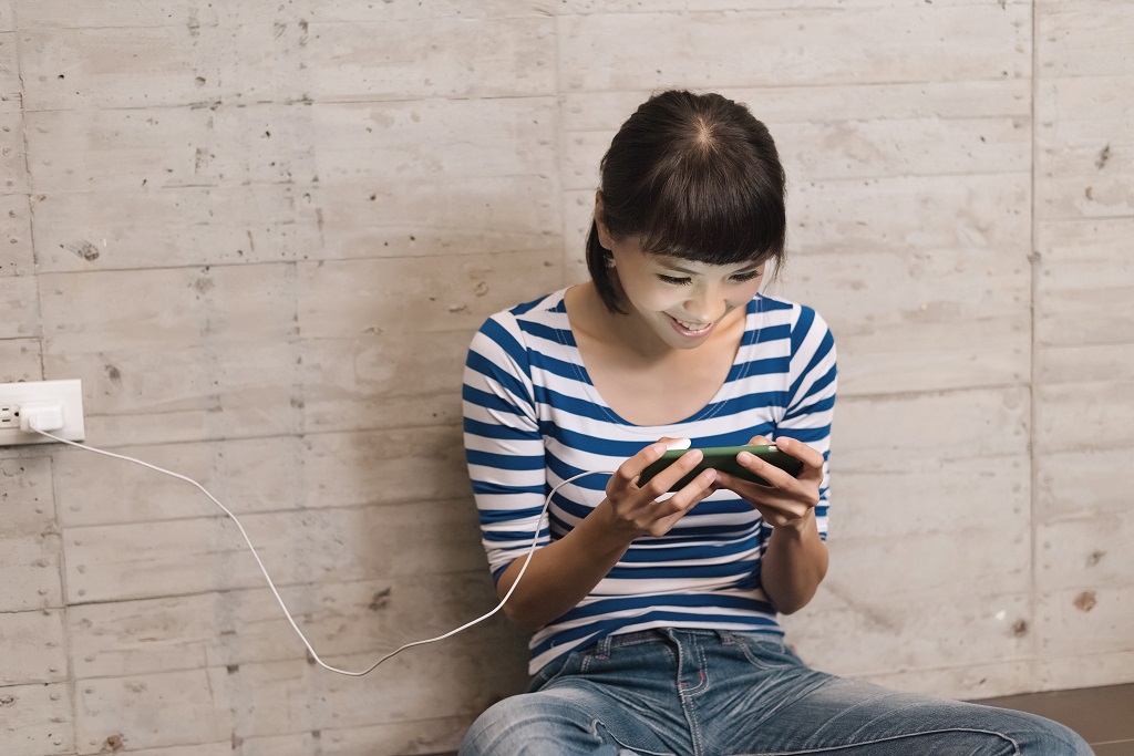 Woman uses cellphone while charging.