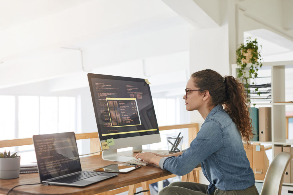 Programmer with black and orange colored codes on different screens.