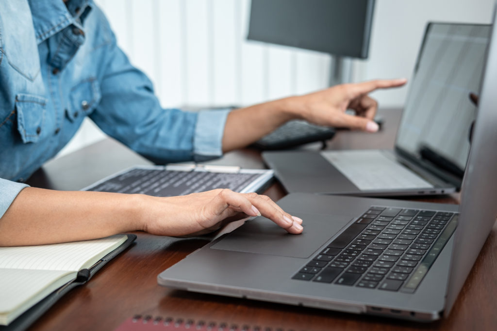 Woman using multiple laptop screens.