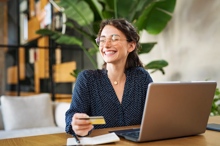 Woman with laptop using credit card