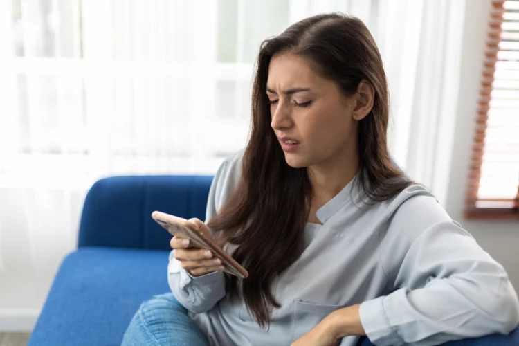 Woman checks out phone with serious face
