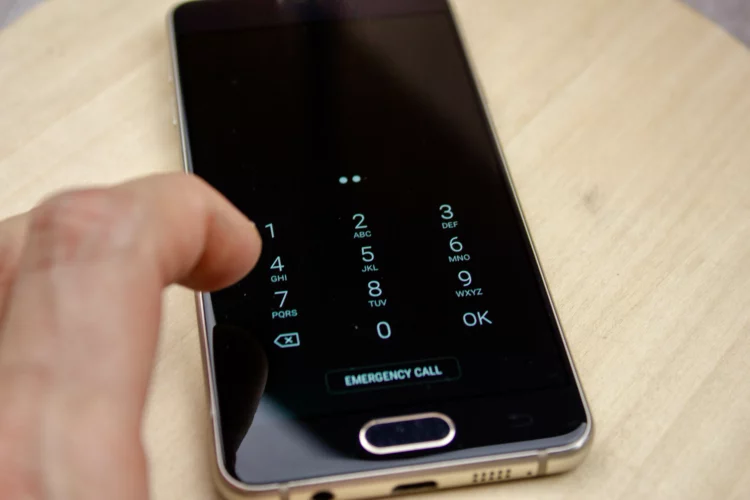 male hand entering smartphone pin code