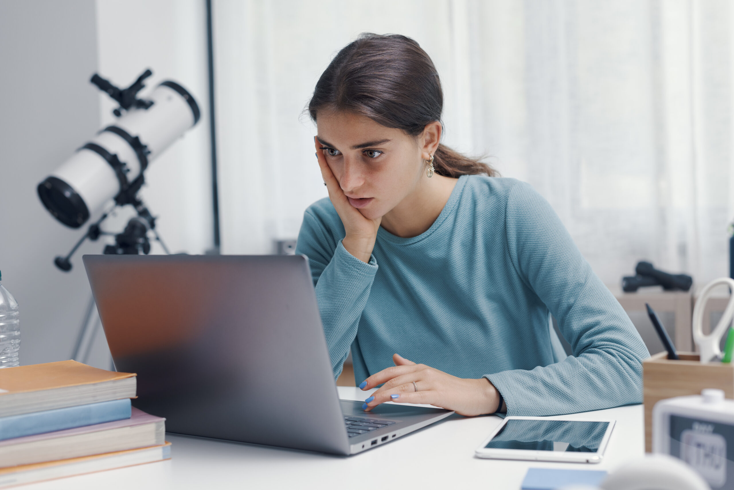 Upset young woman looking at her laptop
