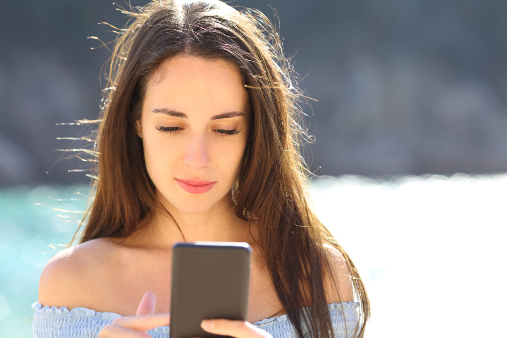 Woman with a serious face checking her phone.