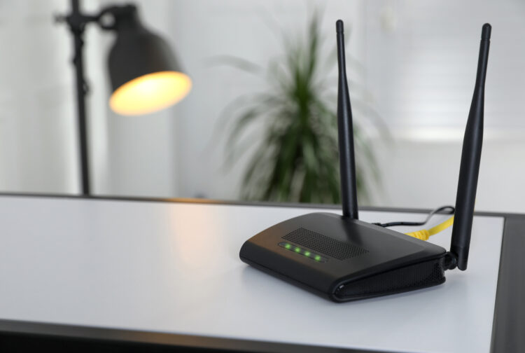 Modern wi-fi router on table indoors