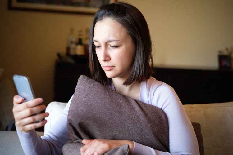 Angry woman reading message on mobile phone