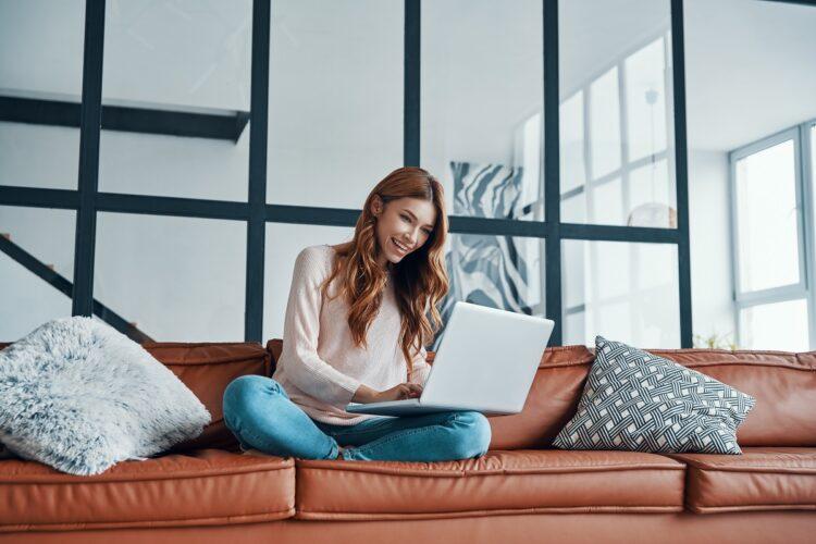 Attractive young woman using her Lenovo Thinpad getting used to using the middle button as a mouse.