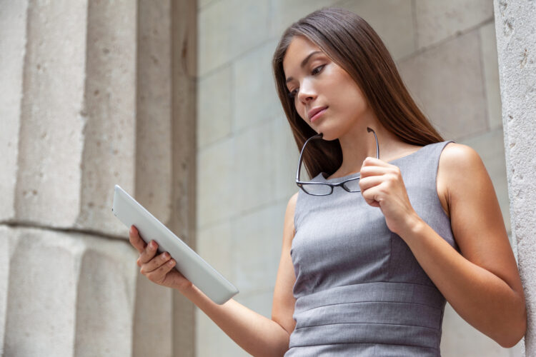 professional woman serious working at courthouse reading on her digital tablet device.