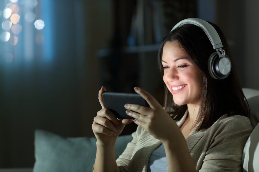 Relaxed woman with headphones watching a video.