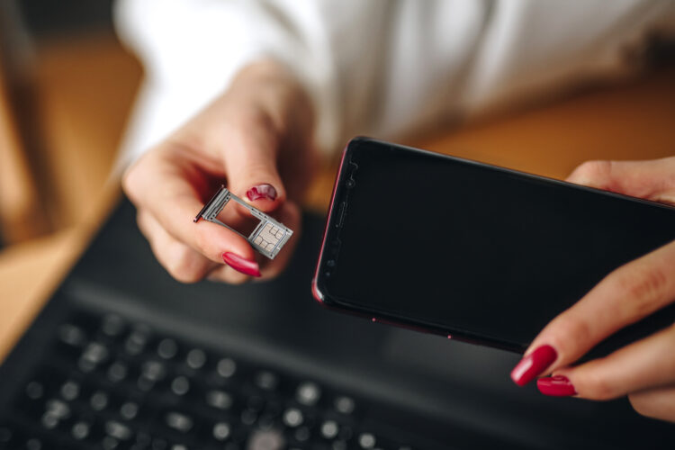 Woman takes out a sim card from the phone.