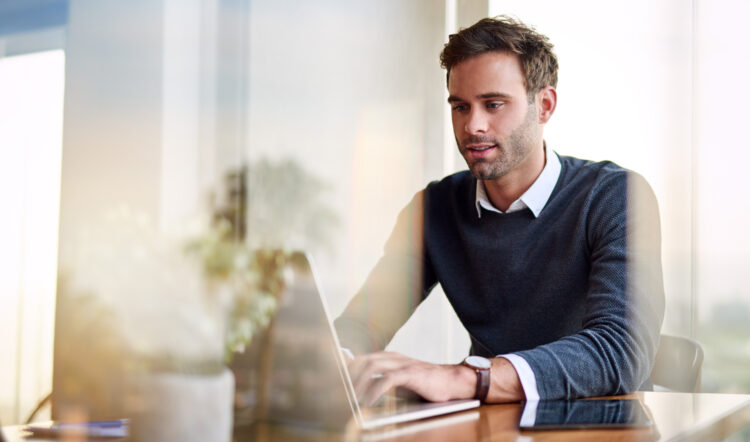 Young man using a laptop while working from home