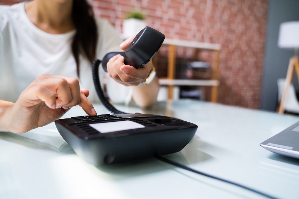 Woman making a landline phone call.