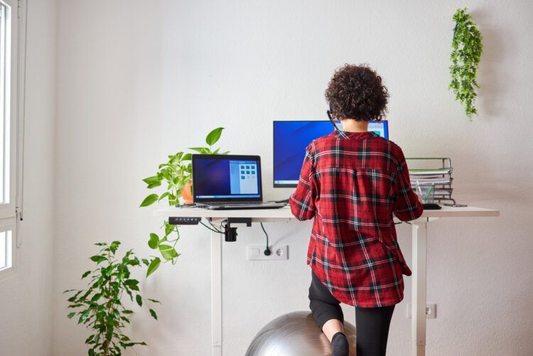 woman teleworking at an adjustable standing desk