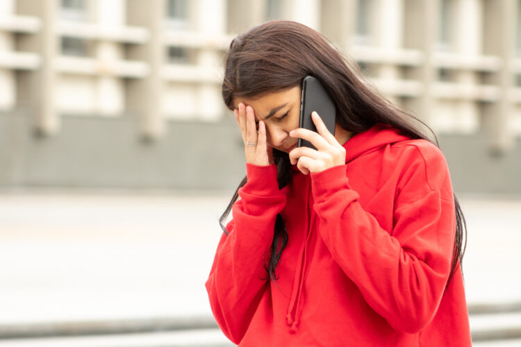 Worried woman on the phone on the street