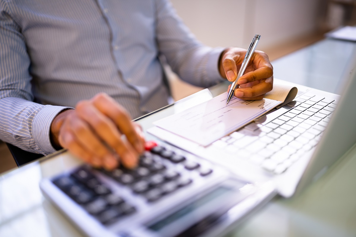 man writing payroll compensation checks