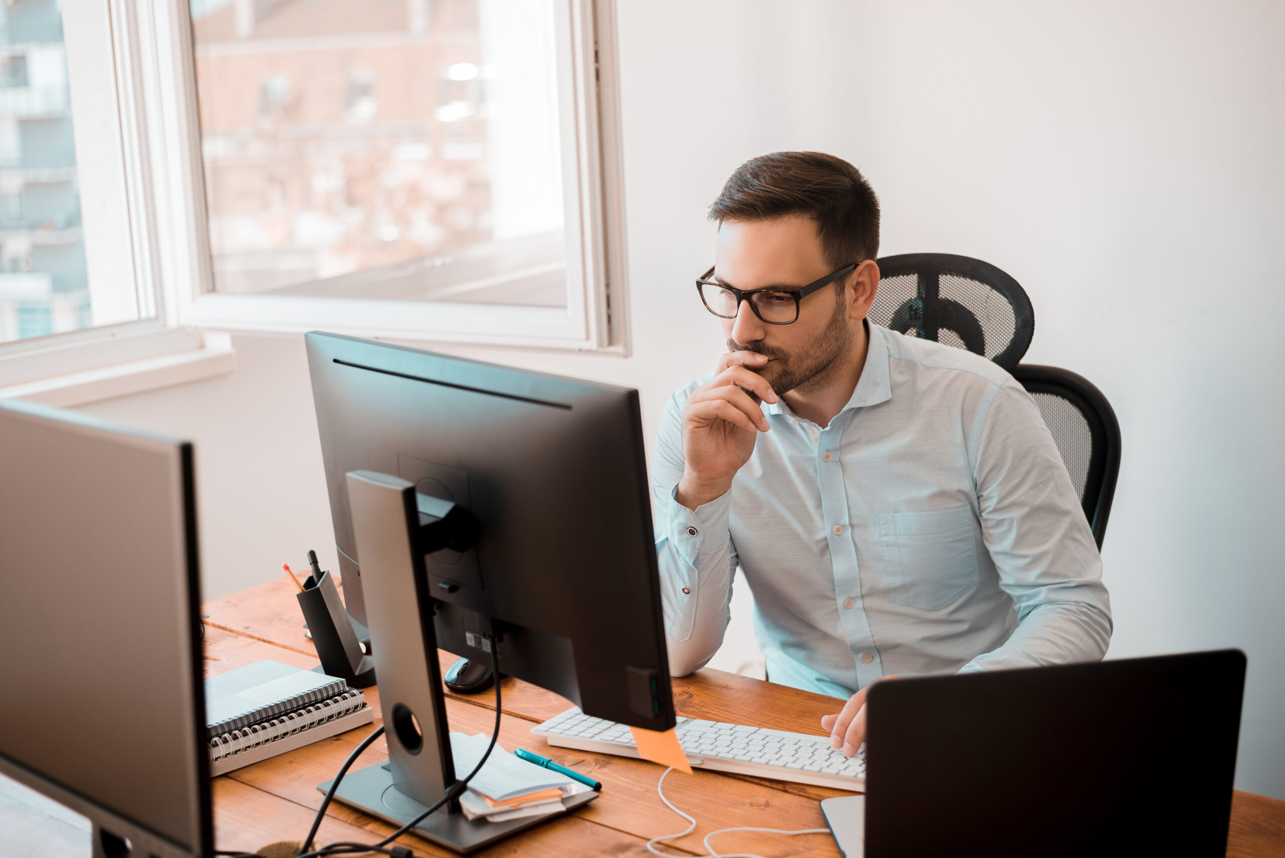 Man working on computer in modern office interior.