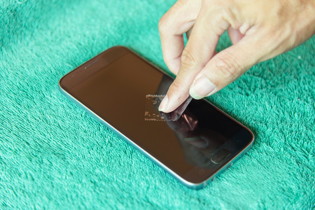 cleaning mobile phone screen by adhesive clear tape. 