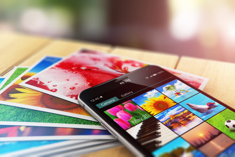 Stack of photos and smartphone with image gallery app