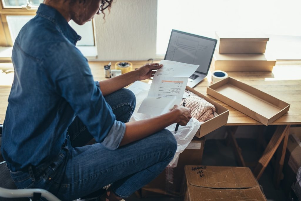 Woman looking at an invoice along with parcel.