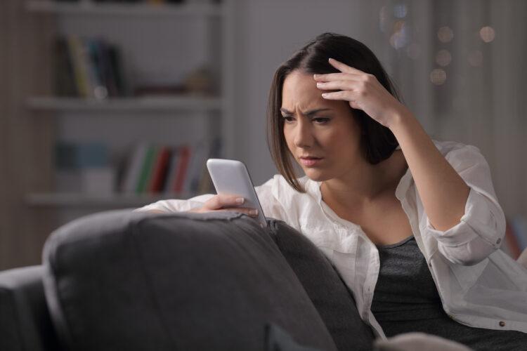 
Worried girl checking smart phone in the night