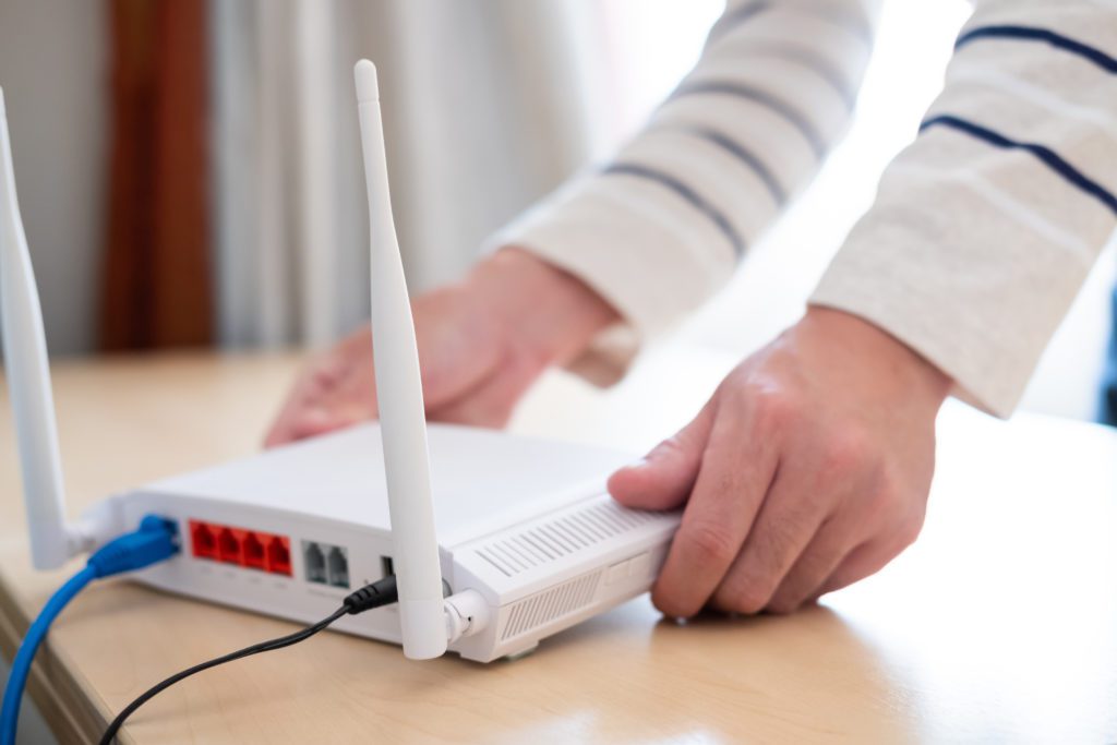 Men sets up and installs internet Wifi router.